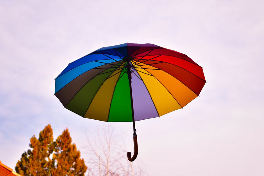 Multi-colored umbrella floating in air